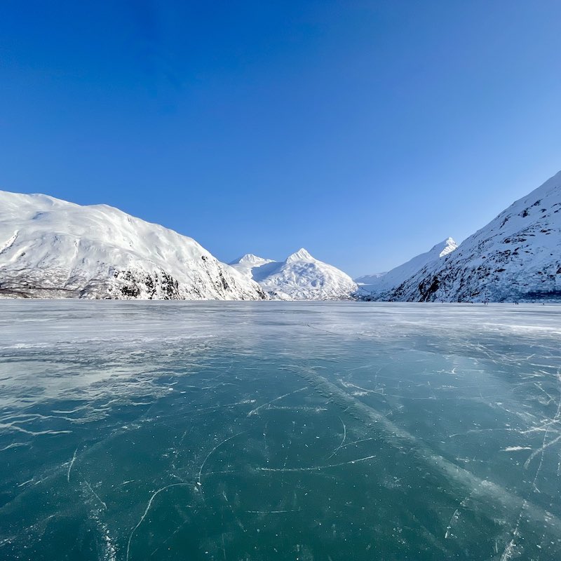 Frozen lake and snowy mountains leading to Exit Glacier.